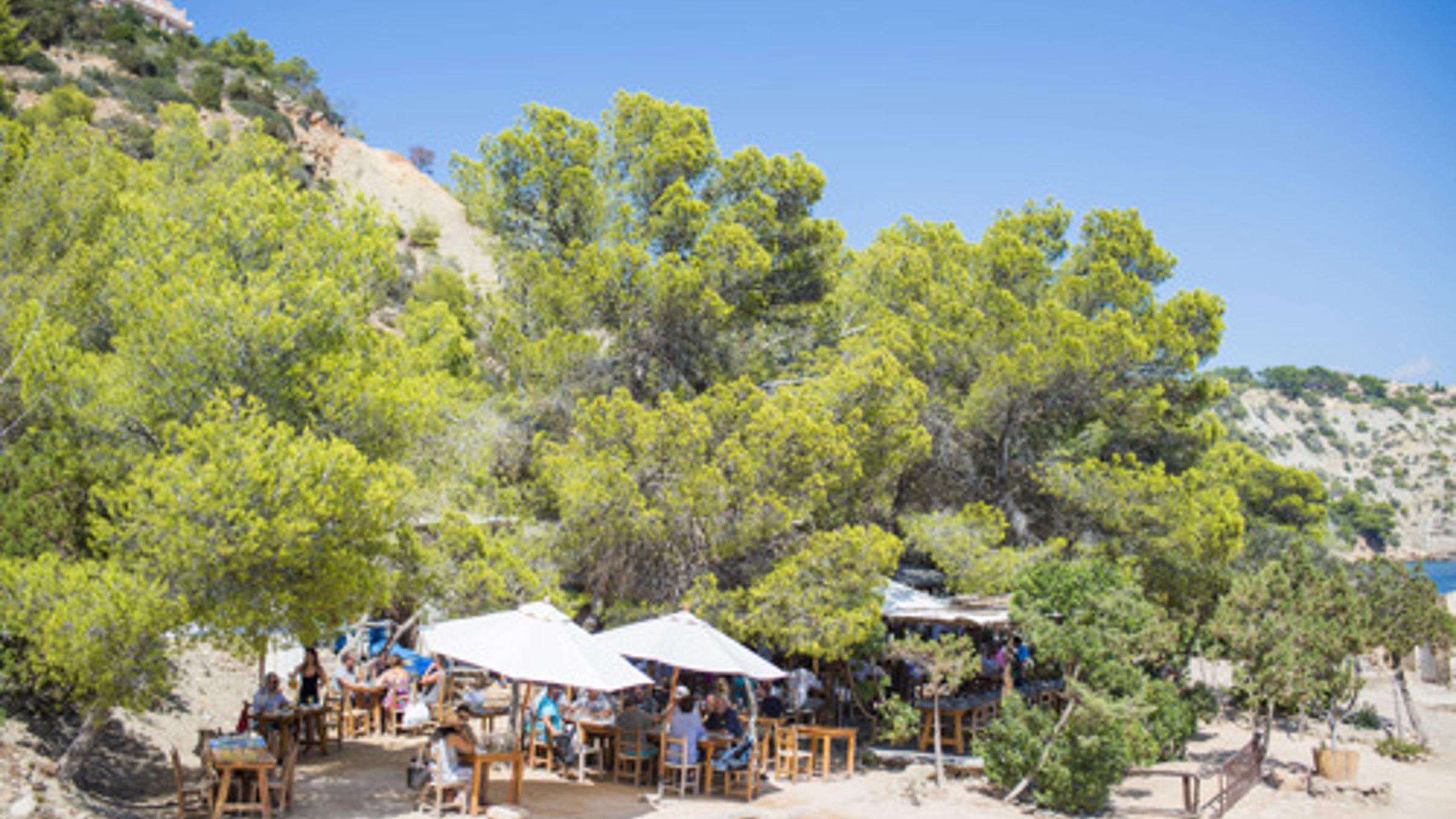 Beach Restaurant With People Seatting Under Umbrella