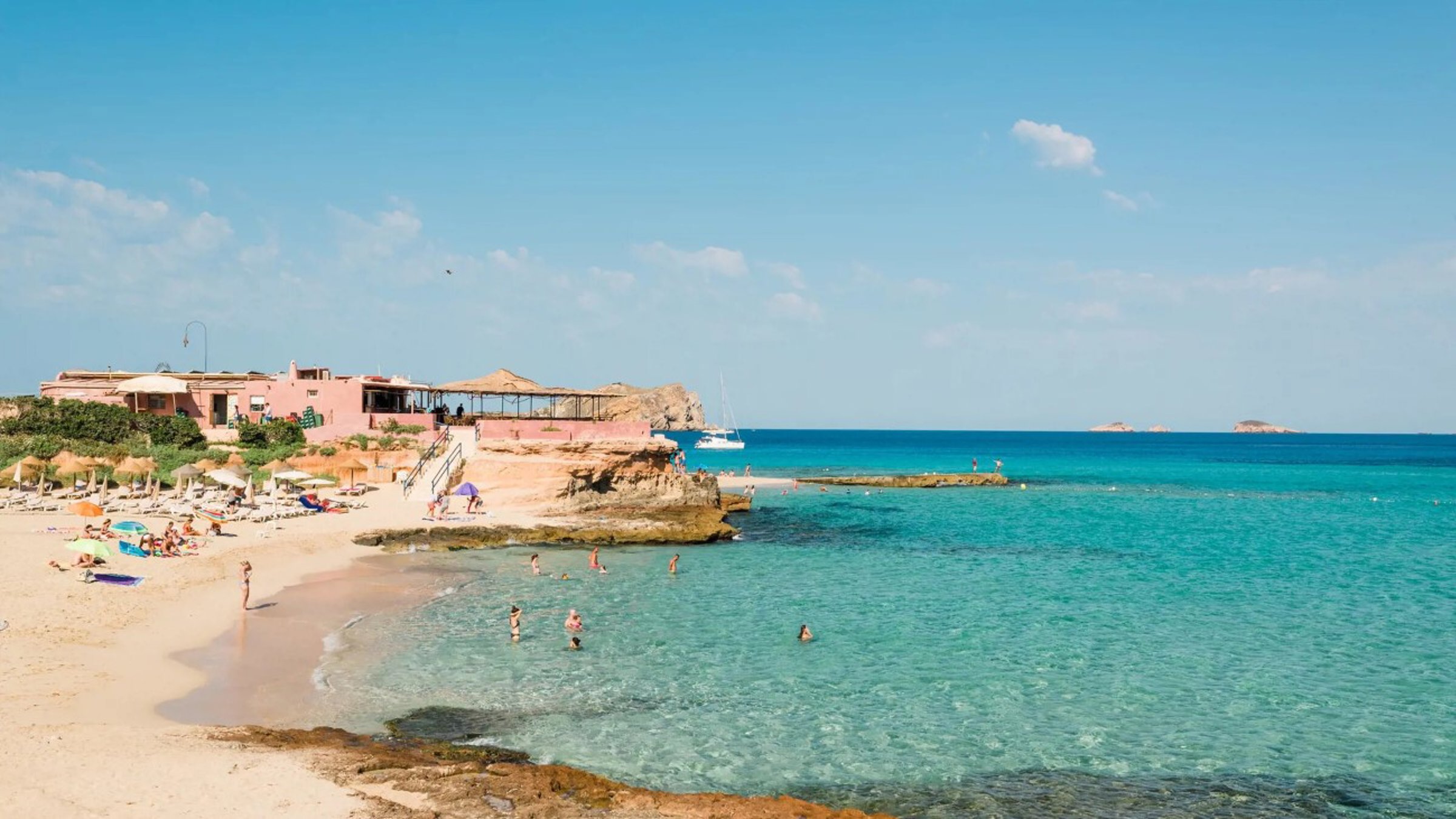 Beach With Turcoise Sea And People Seating By The Sea (1)