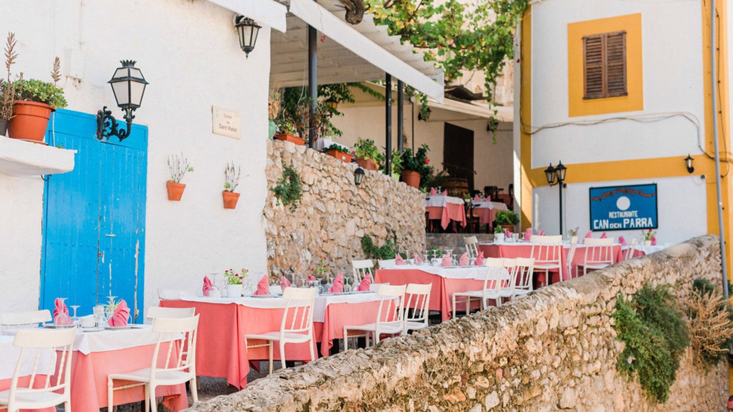 Tables And Chairs On Street Between Buildings