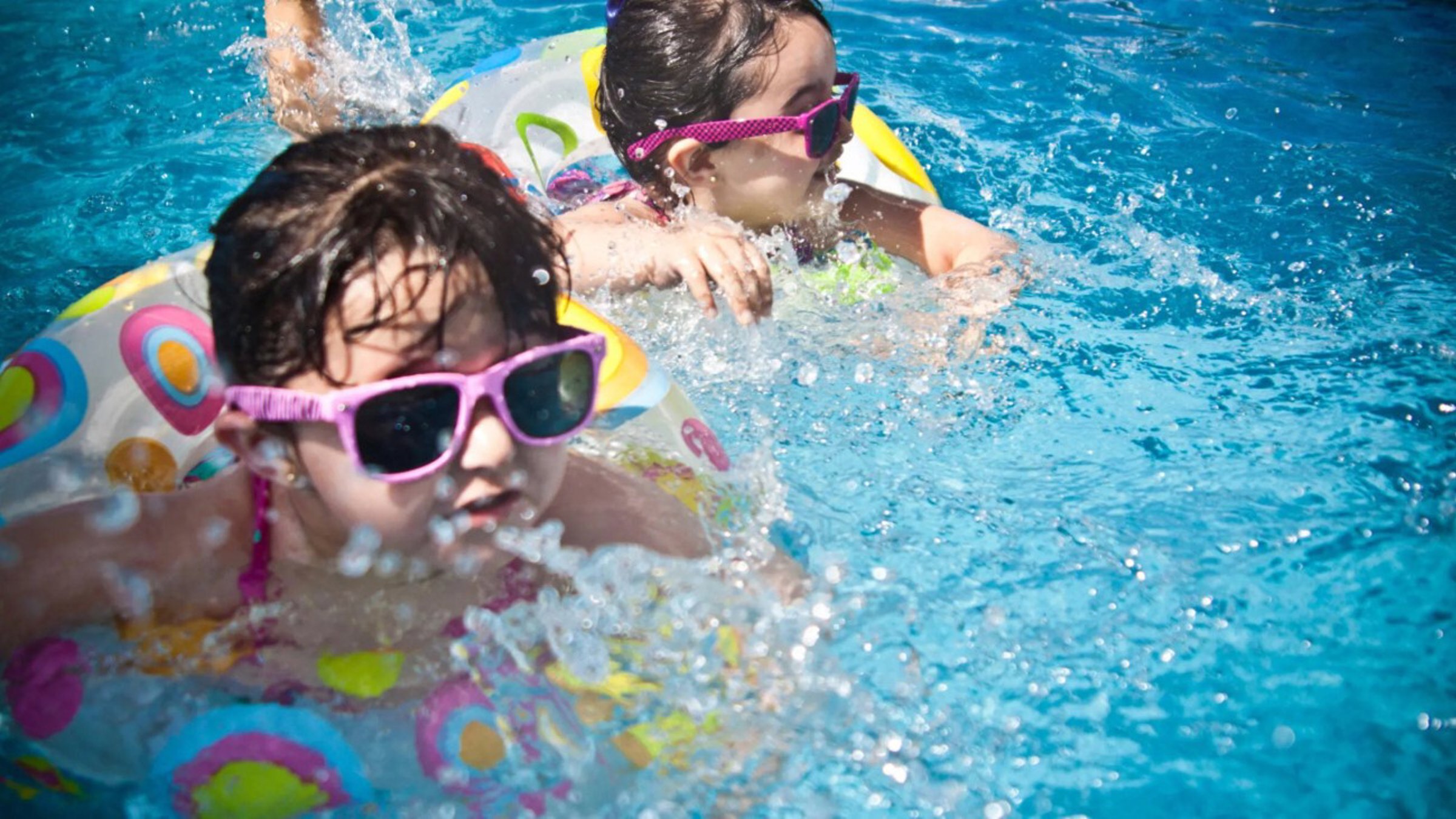 Two Little Girls Swimming In The Pool