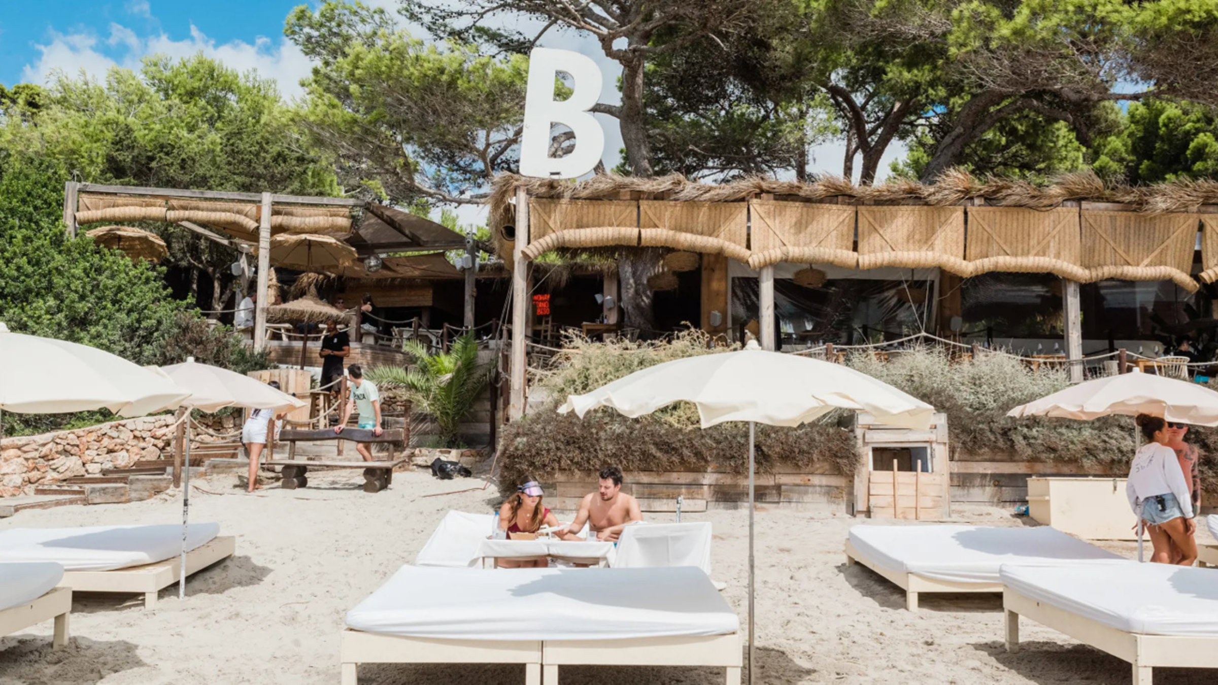 Couple On The Beach Eating On A Sunbed